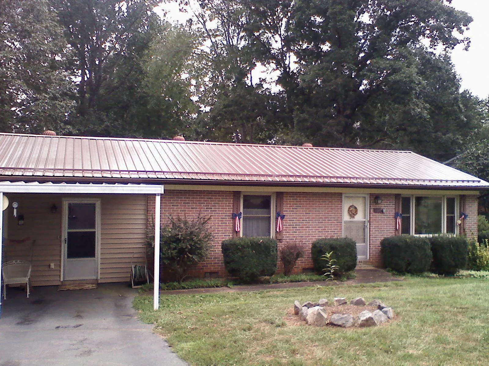 Bronze metal roof and carport on a brick ranch home — Roof Repair work by our crew in Tryon