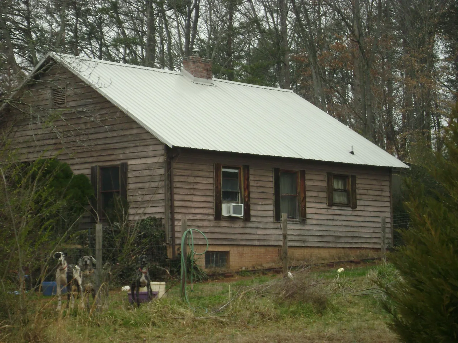 White metal roof on an old wood sided farmhouse, from a Metal Roof Installation job in Tryon